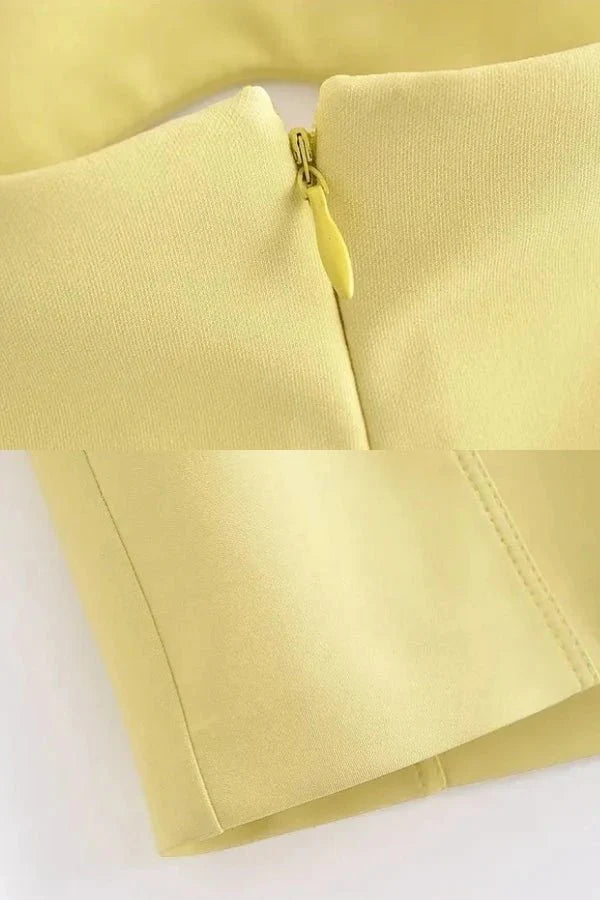 Model wearing the Kouvr Fashion yellow strapless cutout mini dress from the front