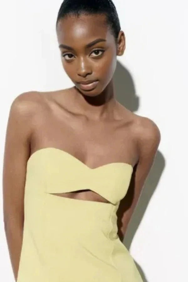 Model wearing the Kouvr Fashion yellow strapless cutout mini dress from the front