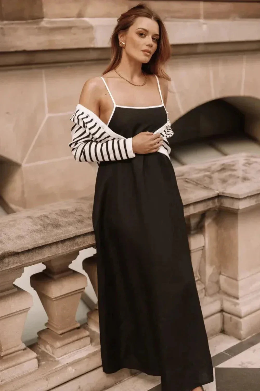 Model wearing Kouvr Fashion black linen maxi dress with white tie-back straps