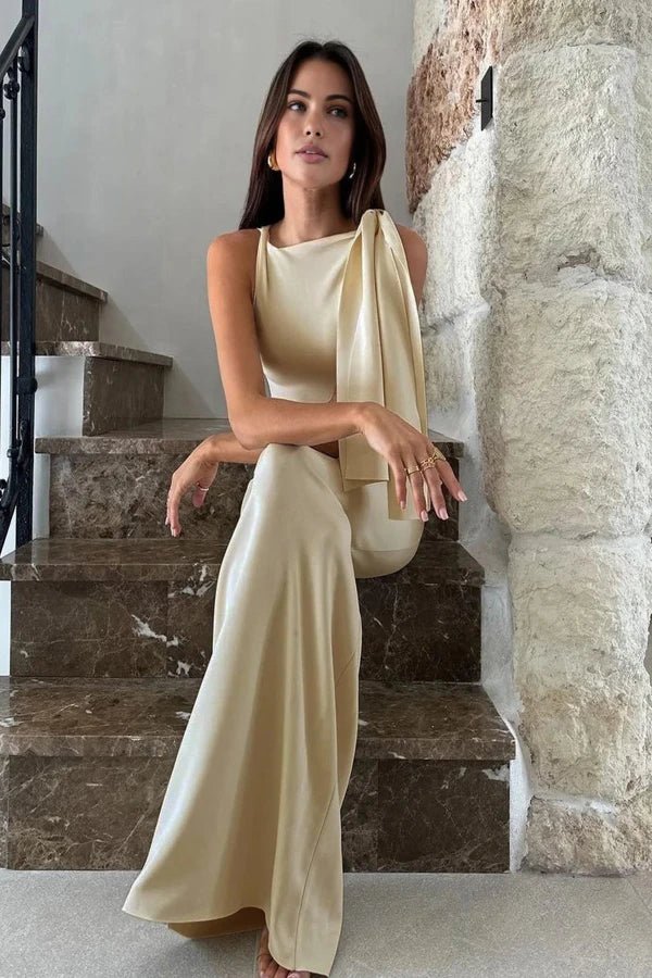 Model wearing the Kouvr Fashion Reese one shoulder satin gown in champagne ivory on a marble staircase