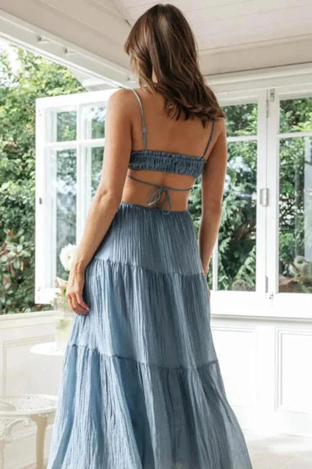 Back view of the Amelia blue maxi dress, showing the smocked back and tie detail.