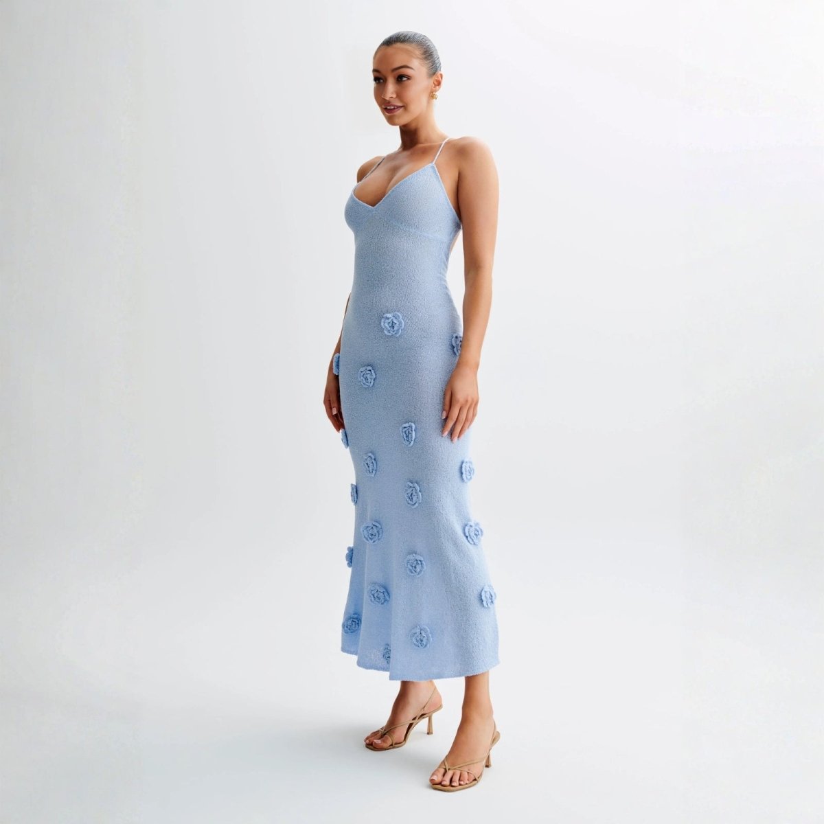 Woman wearing a light blue kouvr dress with floral patterns on a white background