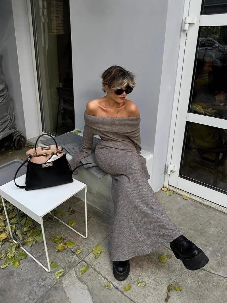 A woman sitting on a bench wearing the Kouvr Ingrid taupe off-the-shoulder knit maxi dress, styled with black platform boots and sunglasses.