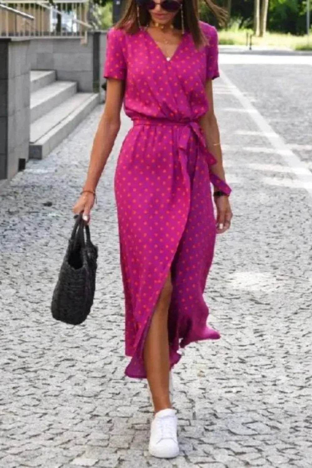 Model walking in the Aleia pink polka dot wrap dress.
