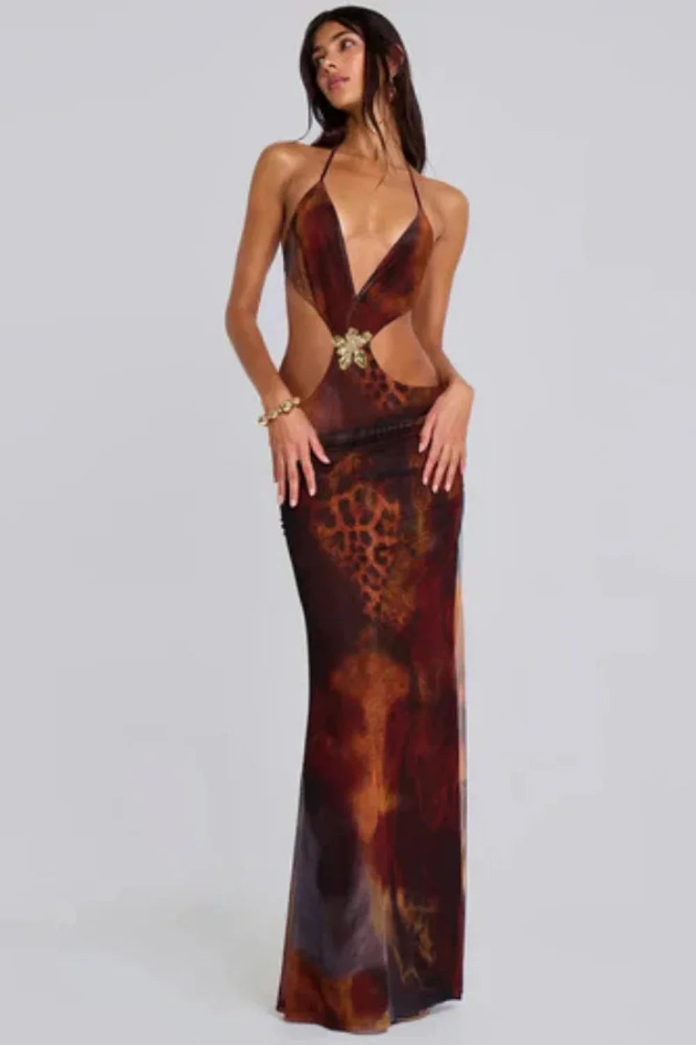 Model wearing the Kouvr Alexa brown leopard print cutout maxi dress with a halter neck and gold butterfly detail
