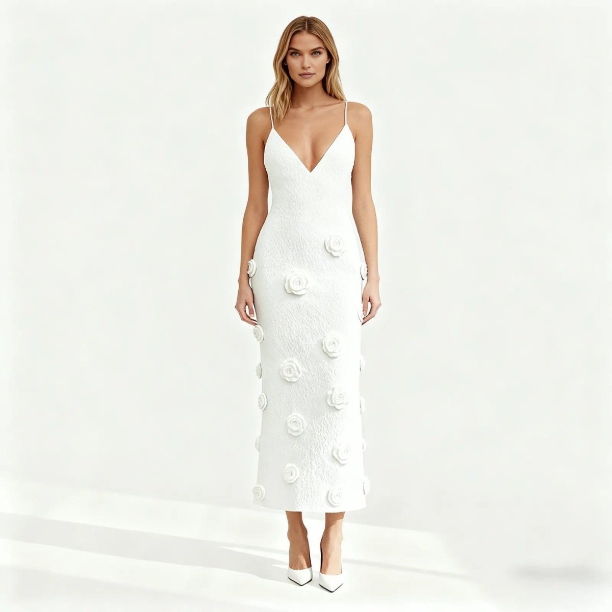 Woman wearing a white dress with floral embellishments on a white background