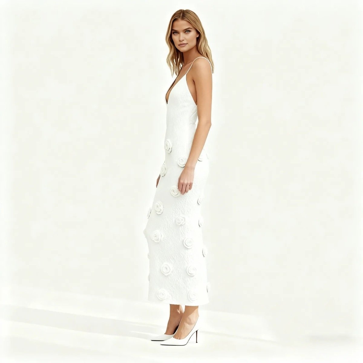 Woman wearing a white dress with floral details on a white background