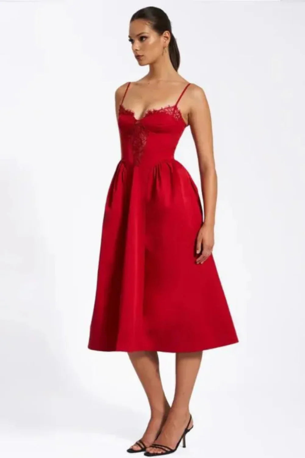 Model wearing Kouvr Amadi red corset midi dress with lace detail and hands in pockets