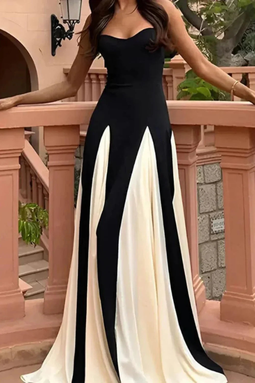 Woman wearing the Kouvr Anastasia black formal gown standing on an elegant marble hallway