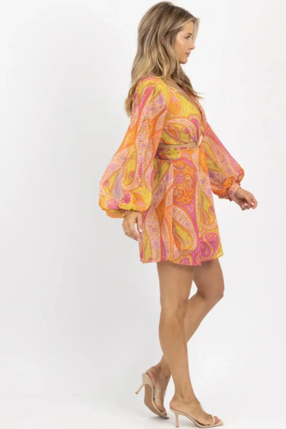 Model wearing Kouvr's long sleeve angelica cutout mini dress in orange