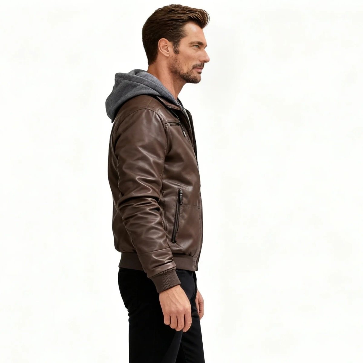 Side profile of a man in a Kouvr Ascend brown hooded moto-style bomber jacket, highlighting the slim fit and layered look.