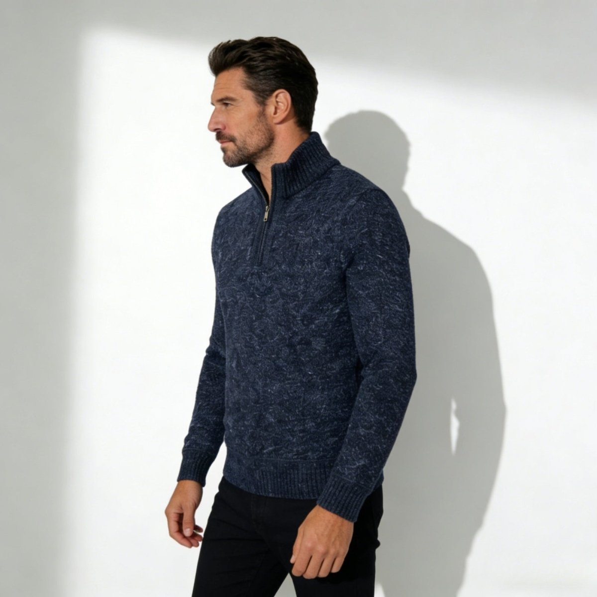 Man wearing the Kouvr Elyson men's textured quarter-zip sweater in a deep navy marl, styled with black trousers.