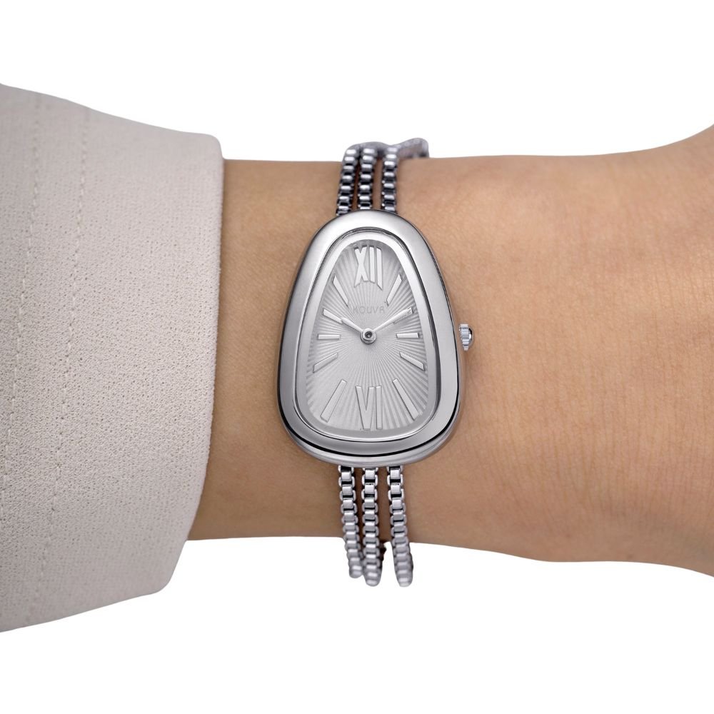 Silver kouvr watch on a wrist with a plain background