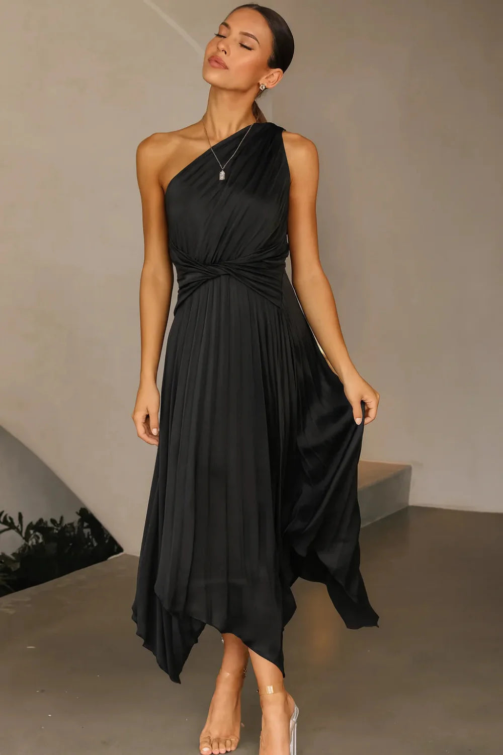 Model wearing the Kouvr Audrine one shoulder silk gown in black, showcasing its draped, asymmetrical design
