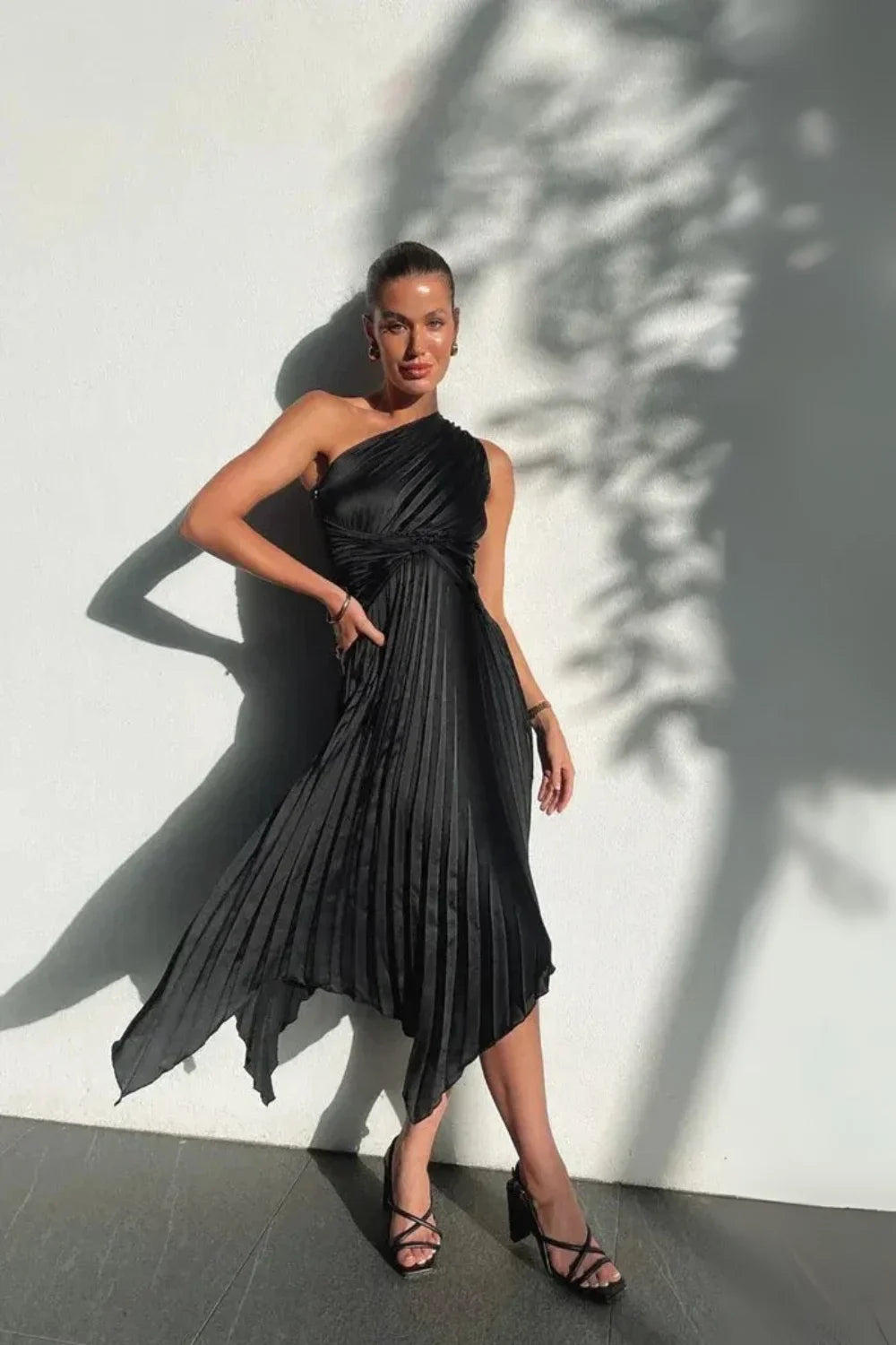 Model wearing the Kouvr Audrine one shoulder silk gown in black, showcasing its draped, asymmetrical design