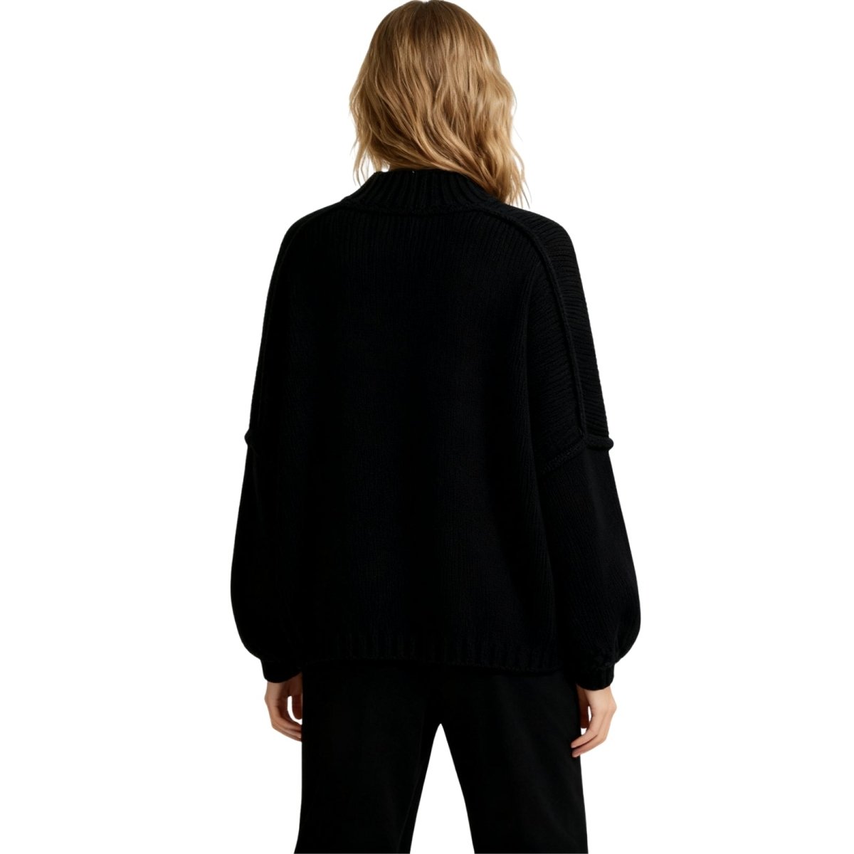 Woman wearing the Kouvr black oversized chunky knit cardigan with large gold buttons