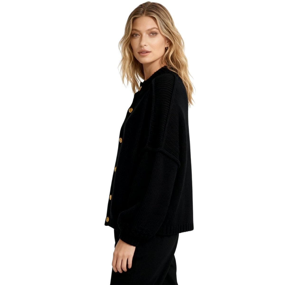 Woman wearing the Kouvr black oversized chunky knit cardigan with large gold buttons