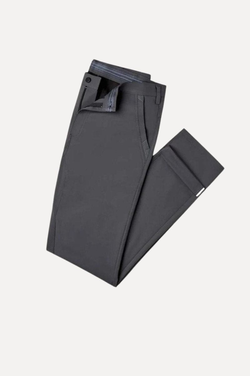 Man wearing Kouvr Calvin black slim fit technical trousers with a navy long-sleeve shirt and white sneakers