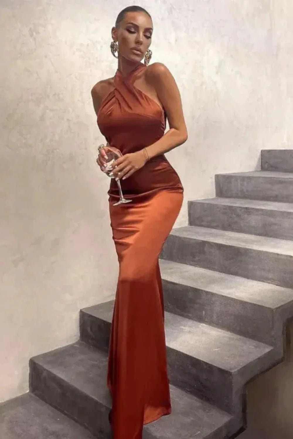Woman wearing Kouvr Camina brown satin halter neck maxi dress with an open back
