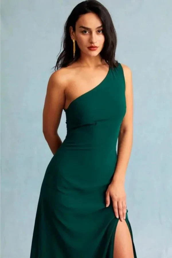 Kouvr Charel Gown in green featuring a one-shoulder neckline and thigh-high slit, worn by a model against a blue background