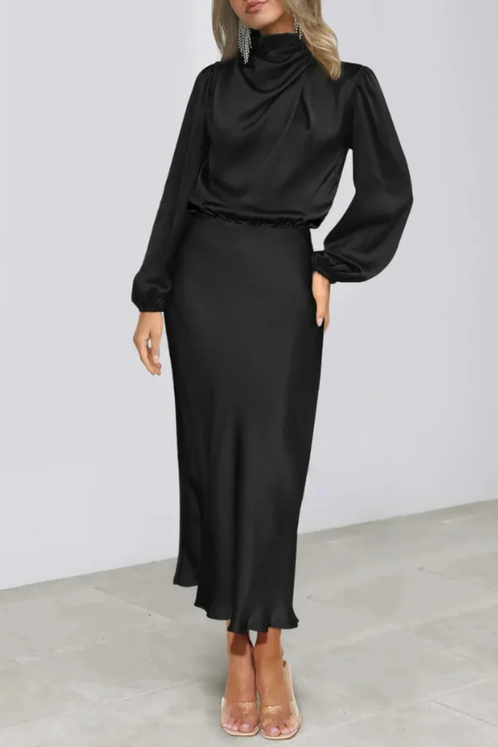 Model viewed from the front wearing the Kouvr black satin long sleeve cowl neck midi dress