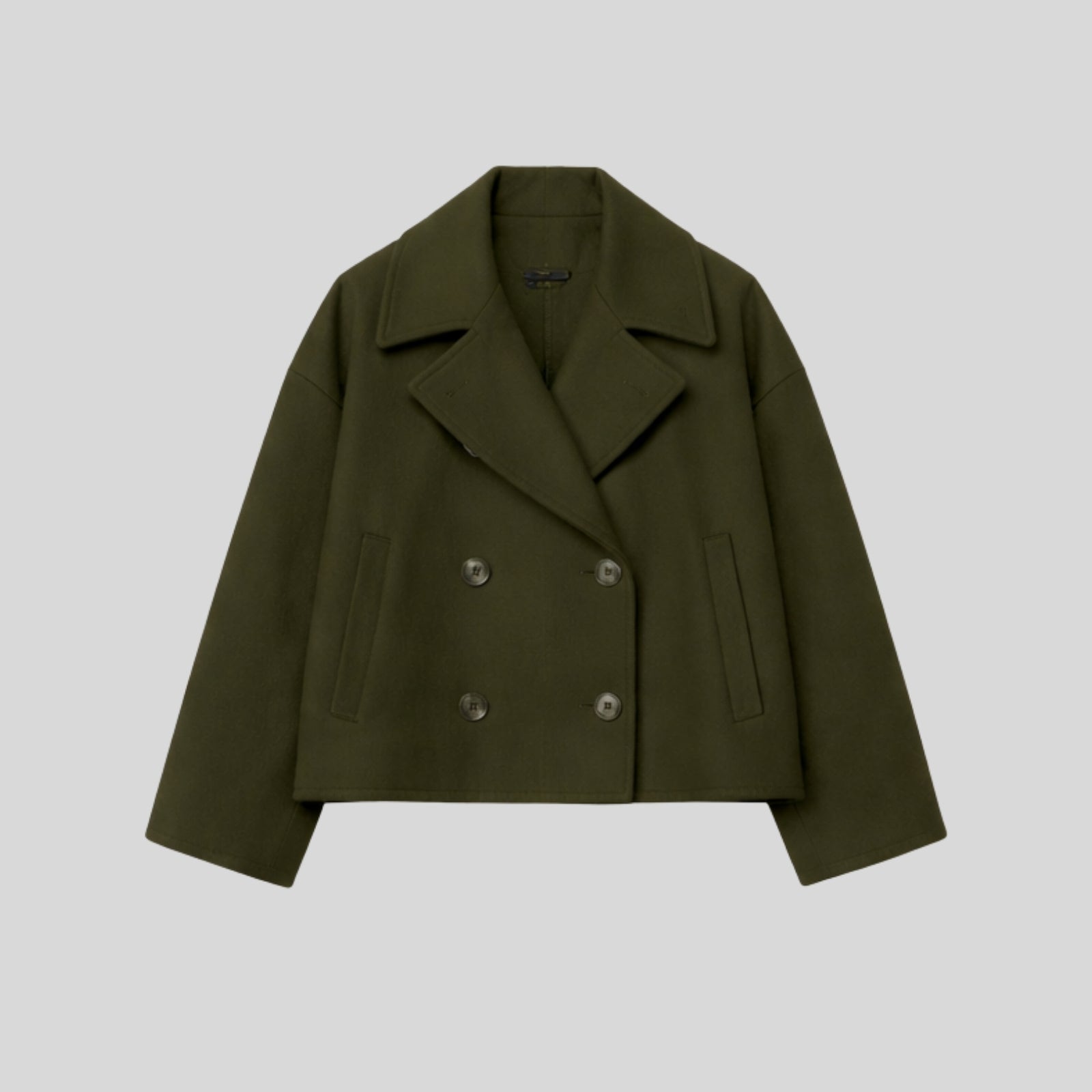 Product-only studio shot of the Kouvr double-breasted cropped wool peacoat in dark green , showing the button details and texture.