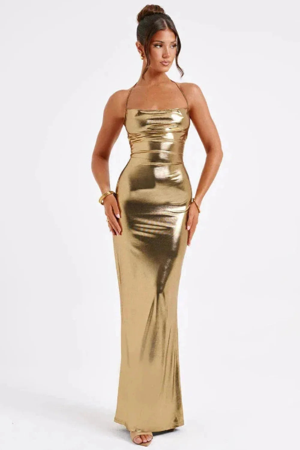 Woman in Kouvr Elysian gold metallic gown with open lace-up back