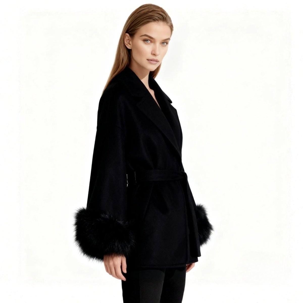 Side profile of a model in the Kouvr Emma black wool wrap coat, highlighting the luxurious fox fur cuffs and elegant silhouette.