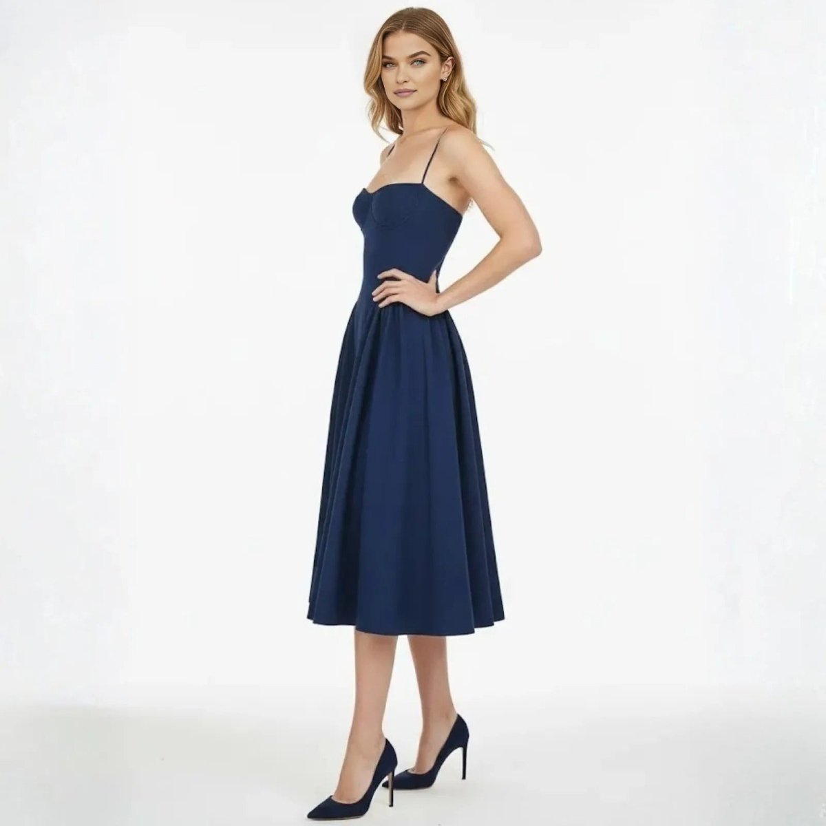 Side view of a model in Kouvr's navy cocktail dress, highlighting the defined waist and A-line silhouette of the midi skirt.