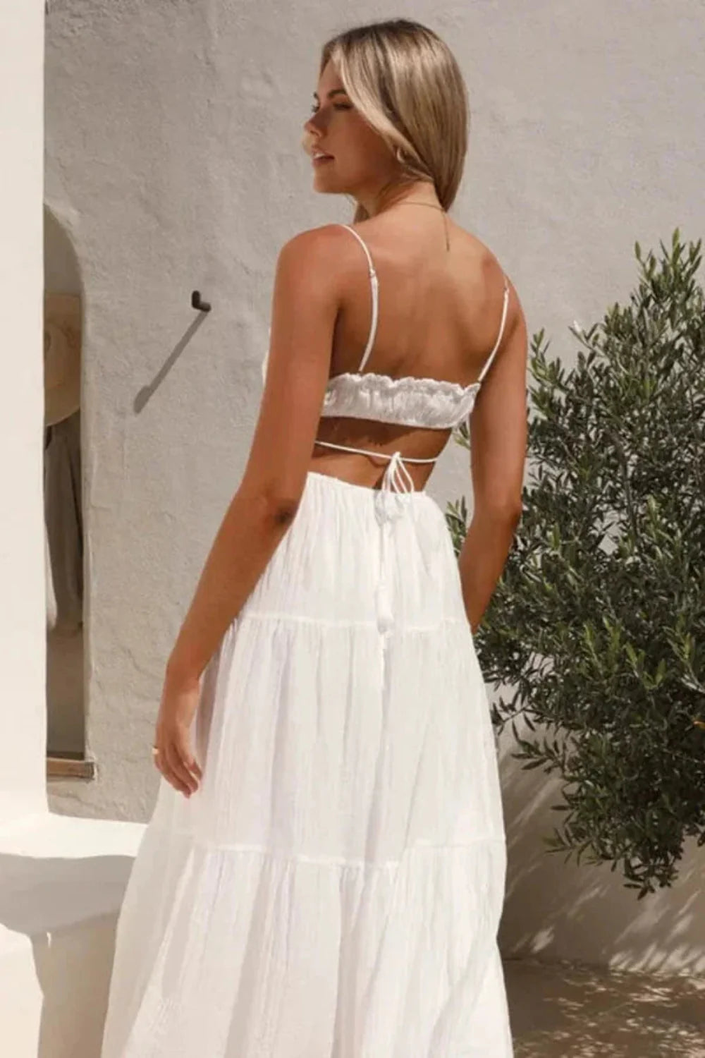 Back view of the Amelia white backless maxi dress by Kouvr, showing the open back and tie details.