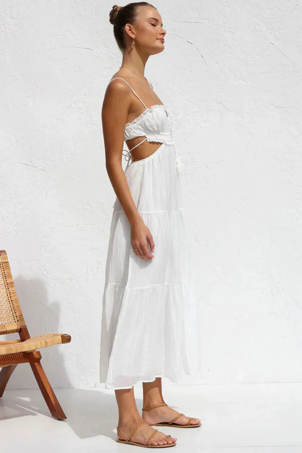 Model wearing the Amelia white cutout tiered maxi dress by Kouvr, front view.