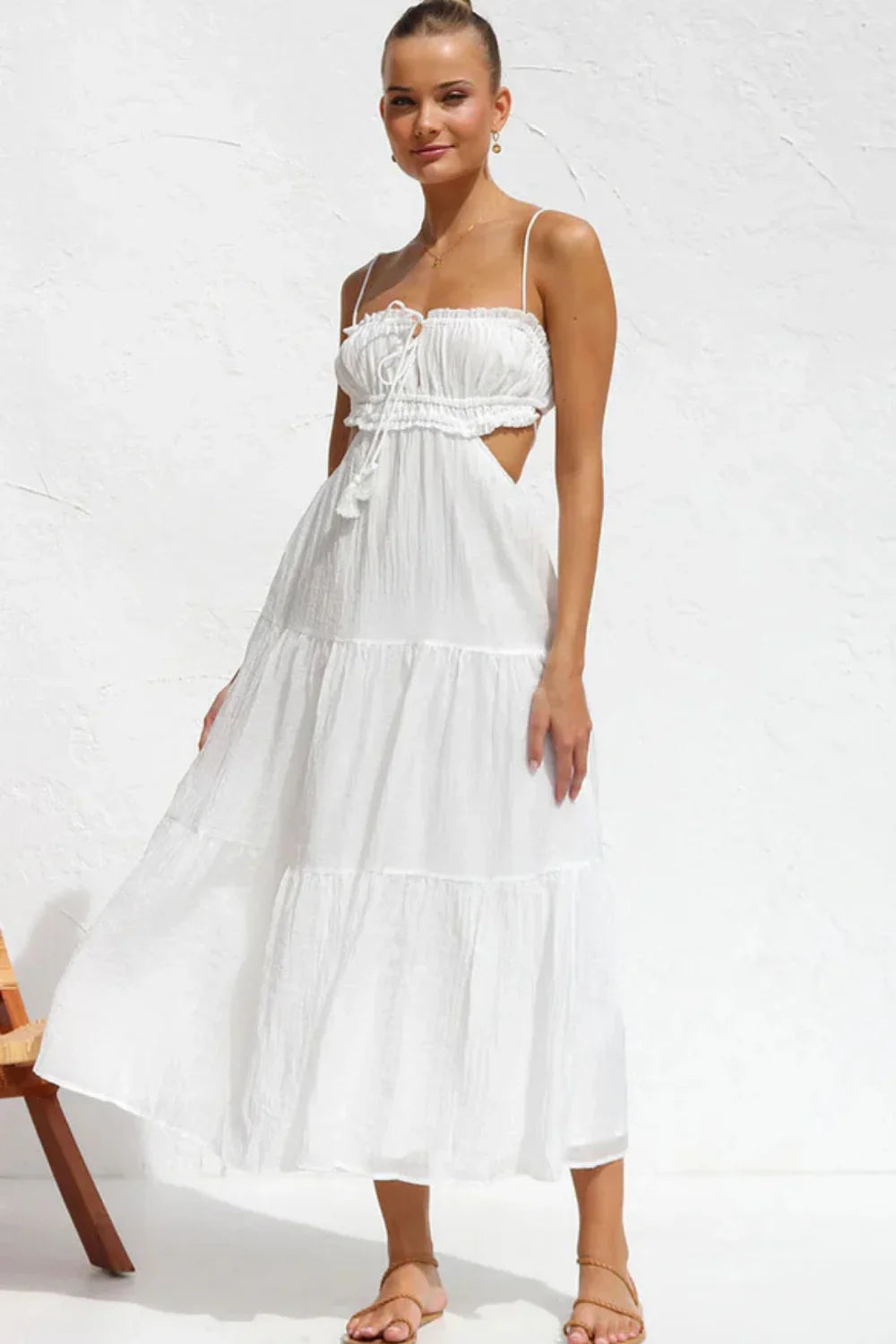 Model wearing the Amelia white cutout tiered maxi dress by Kouvr, front view.
