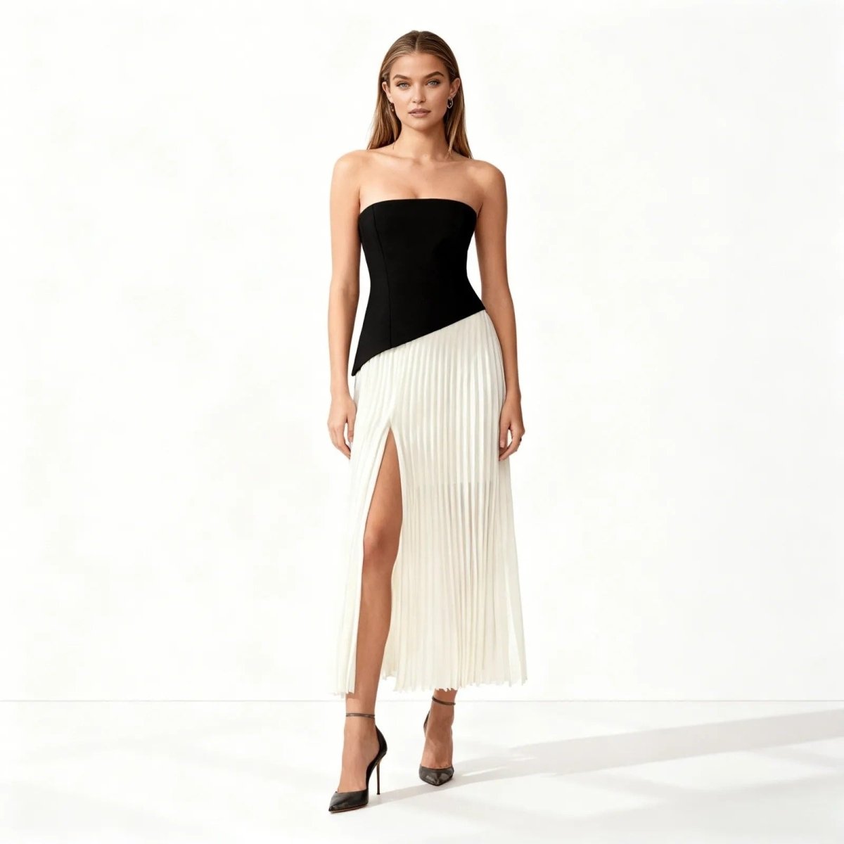 Woman wearing a black and white dress with a slit on a white background