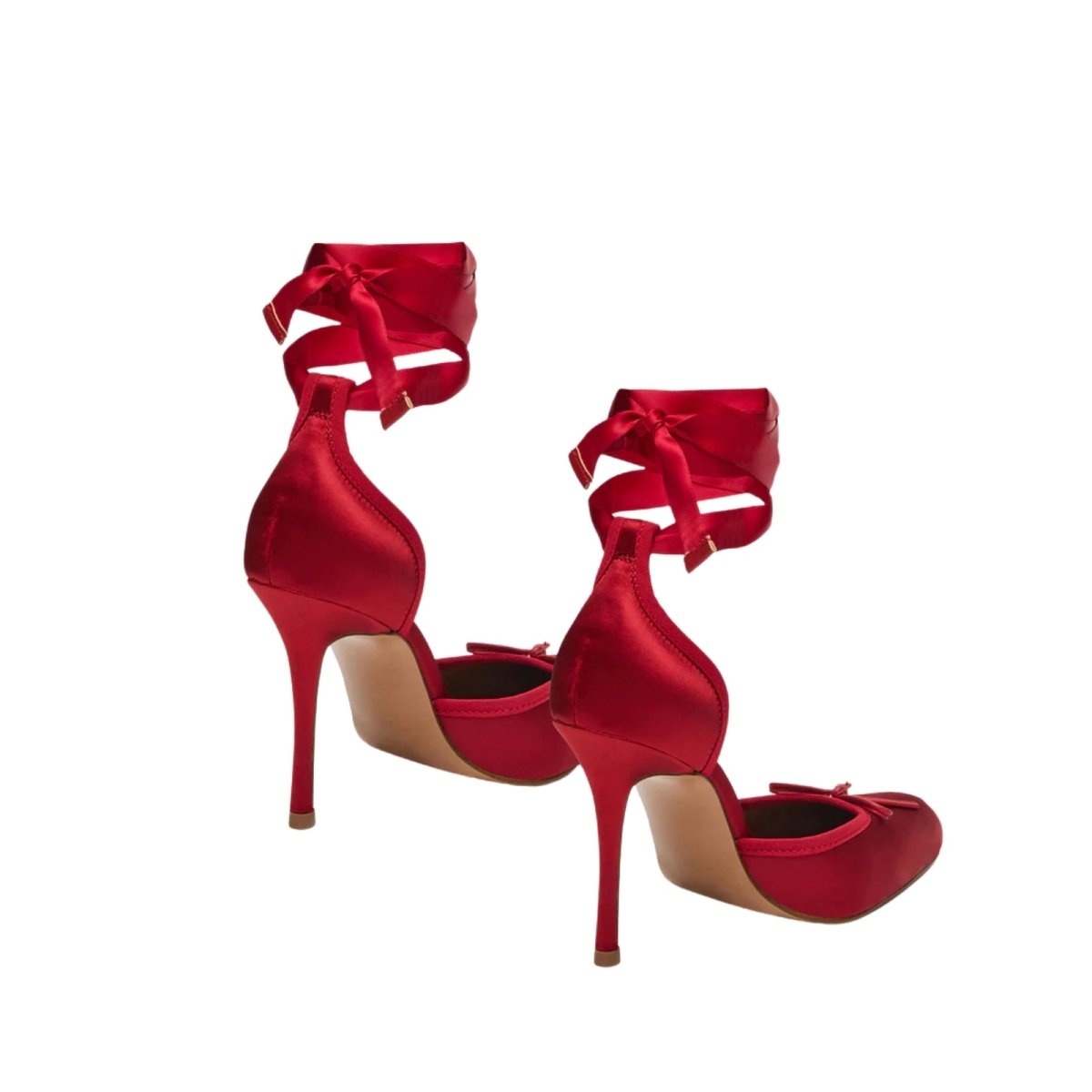 Red kouvr high-heeled shoes with ribbon details on a white background
