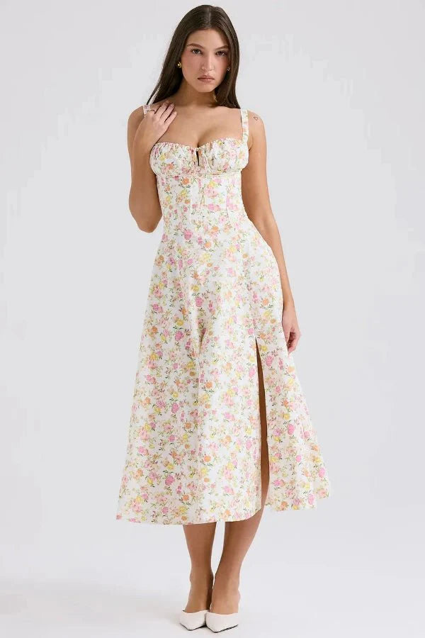 Model wearing Kouvr Fashion Aviva floral corset midi dress in white with pink and yellow flowers, showing the lace-up bustier and A-line skirt