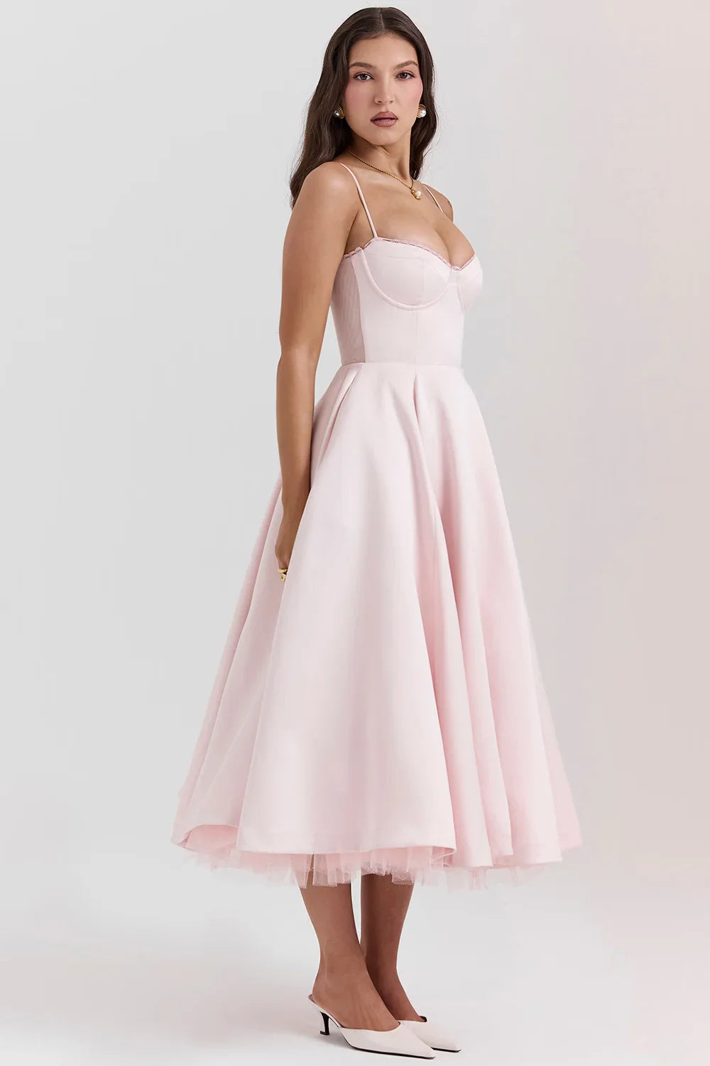 Model from the back wearing Kouvr Fashion's blush pink 1950s style fit and flare dress with a full tulle skirt