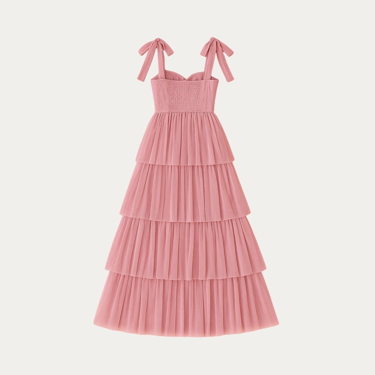 Pink Kouvr tiered dress with bow straps on a light gray background
