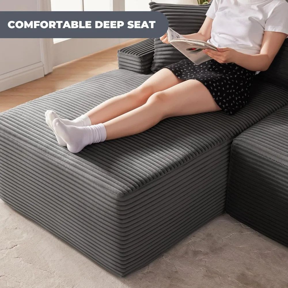 Kouvr modular deep seat sofa in black and dark grey corduroy shown in an L-shape with a beige throw blanket