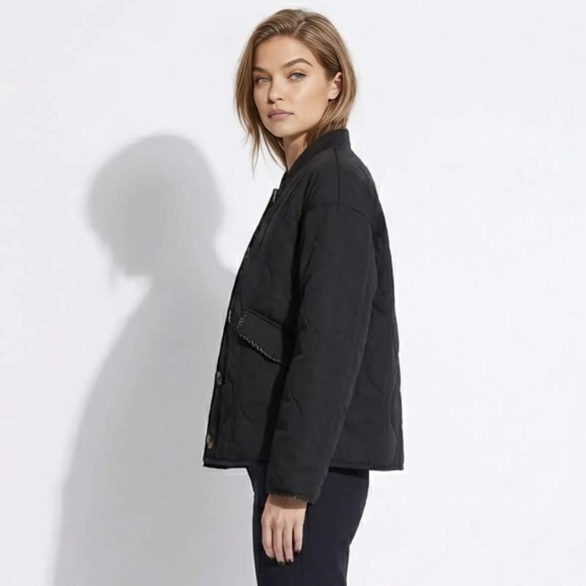 Side profile of a woman wearing the boxy fit black quilted transitional jacket from Kouvr Fashion.