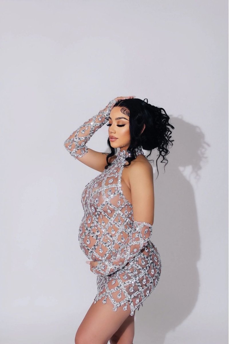 Model wearing the Kouvr Fashion silver crystal embellished sheer halter mini dress with matching long sleeves against a white background