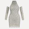 Model wearing the Kouvr Fashion silver crystal embellished sheer halter mini dress with matching long sleeves against a white background