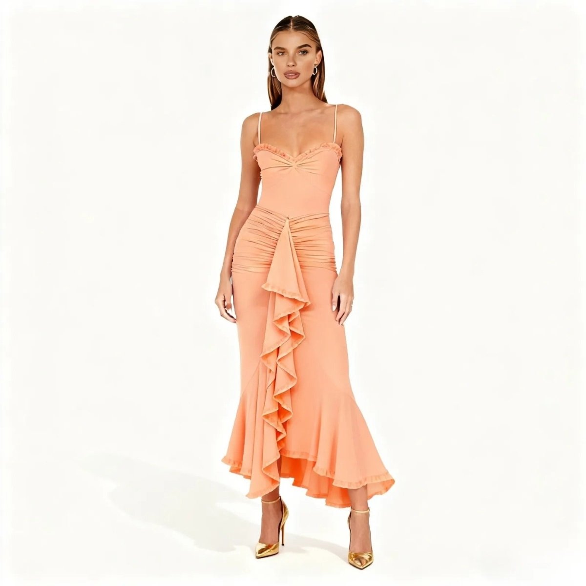 Woman wearing a peach-colored dress with ruffled details on a white background