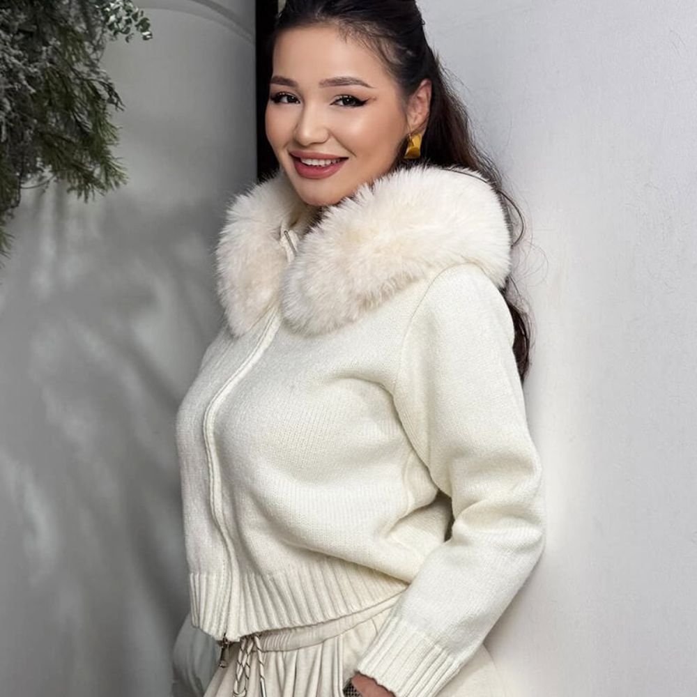 Woman wearing the Kouvr ivory knit hoodie with plush faux fur trim, styled with matching wide-leg pants