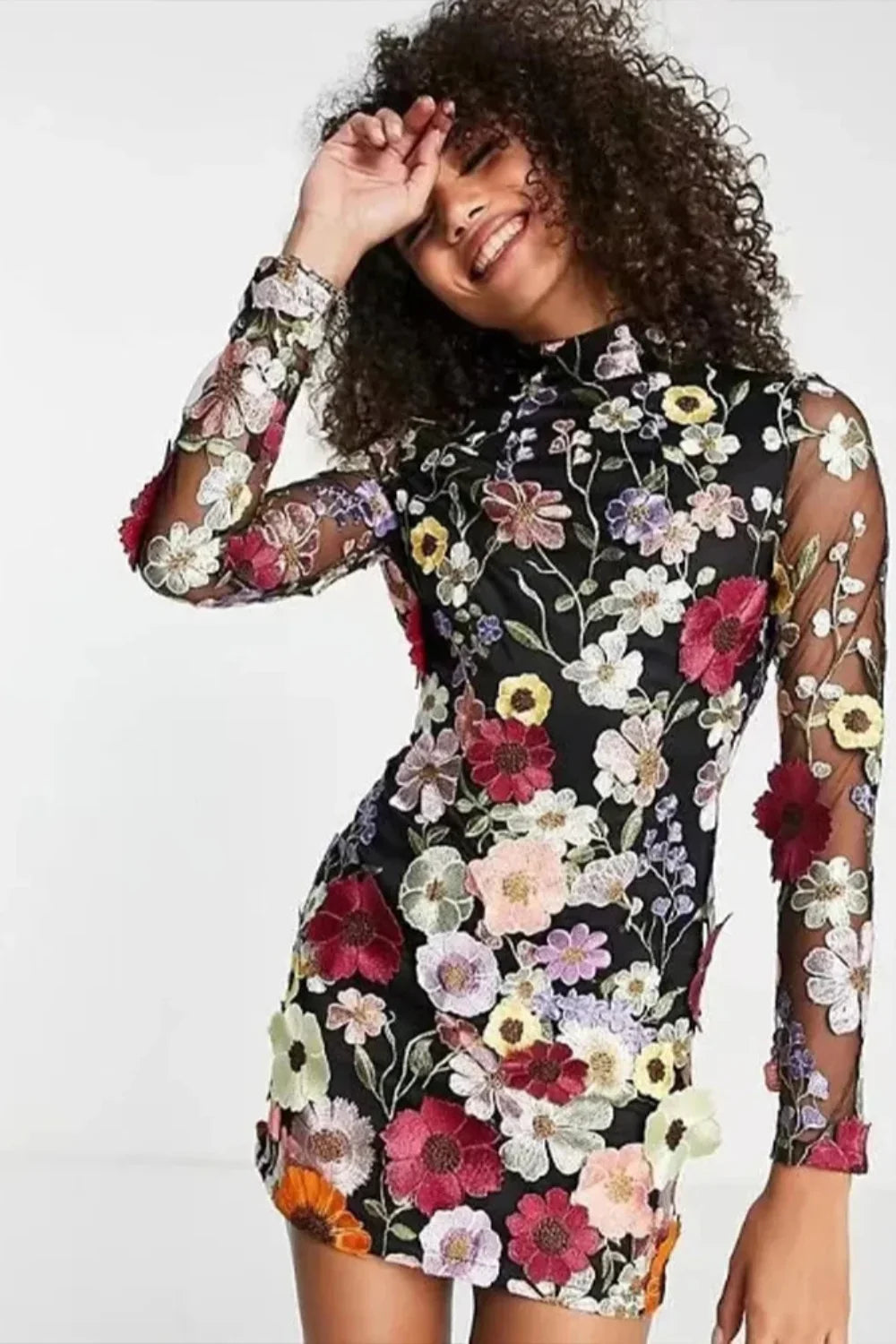 Model in Kouvr Fashion high neck black mini dress with vibrant multicolor 3D floral appliqué embroidery