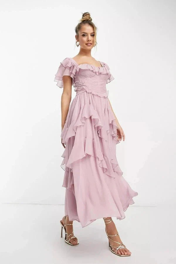 Model wearing Kouvr Fashion Freyna dusty lilac two-piece ruffle dress with corset top and tiered midi skirt