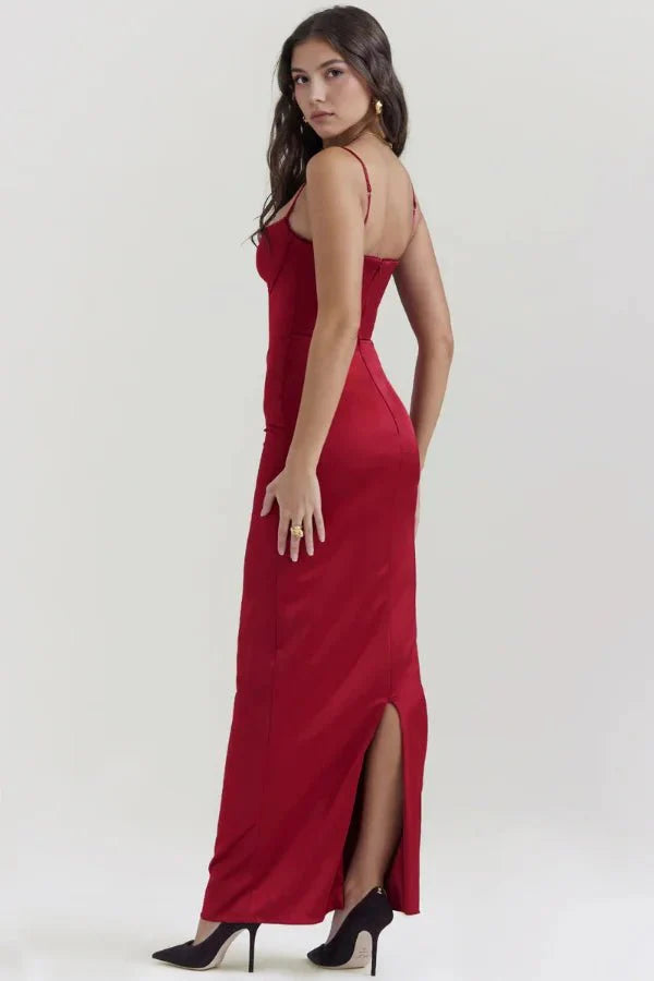 Three-quarter back view of the red Haven satin corset gown, showing the rear slit for movement and the bodycon fit.