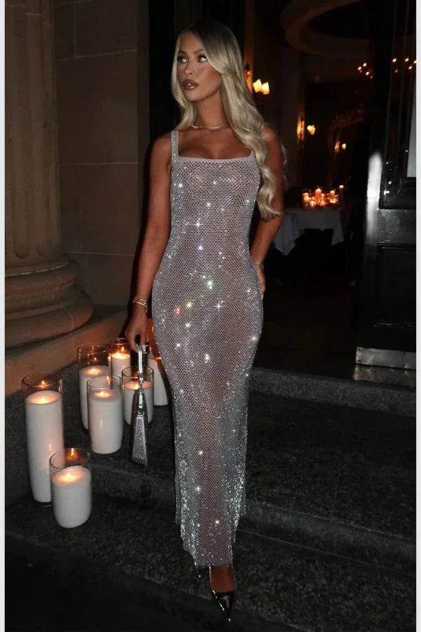 Model wearing the Kouvr Fashion Isabeu Gown, a silver floor-length rhinestone crystal mesh dress with a square neckline