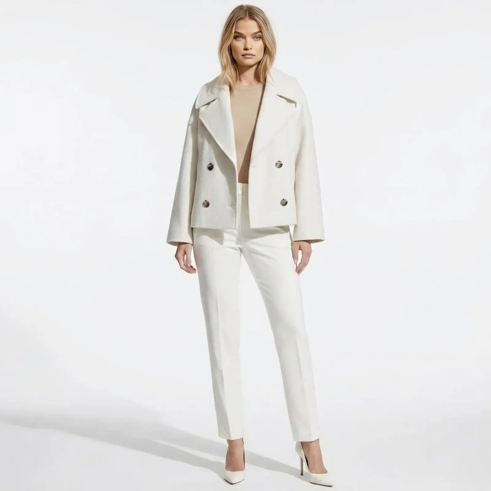 Model wearing the Kouvr Fashion Katherine white cropped wool pea coat and matching trousers, showcasing the double-breasted front and tailored fit.