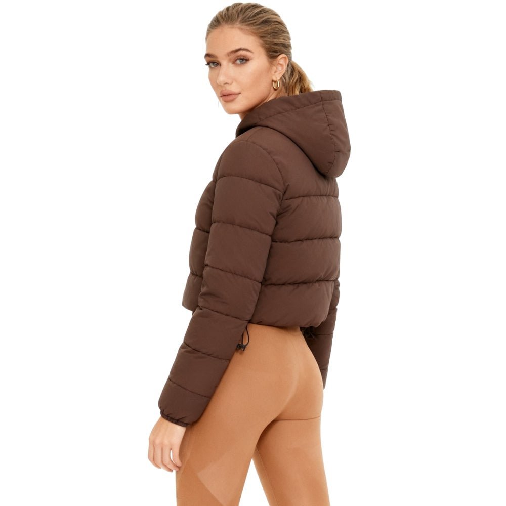 Woman wearing a brown Kouvr puffer jacket on a white background