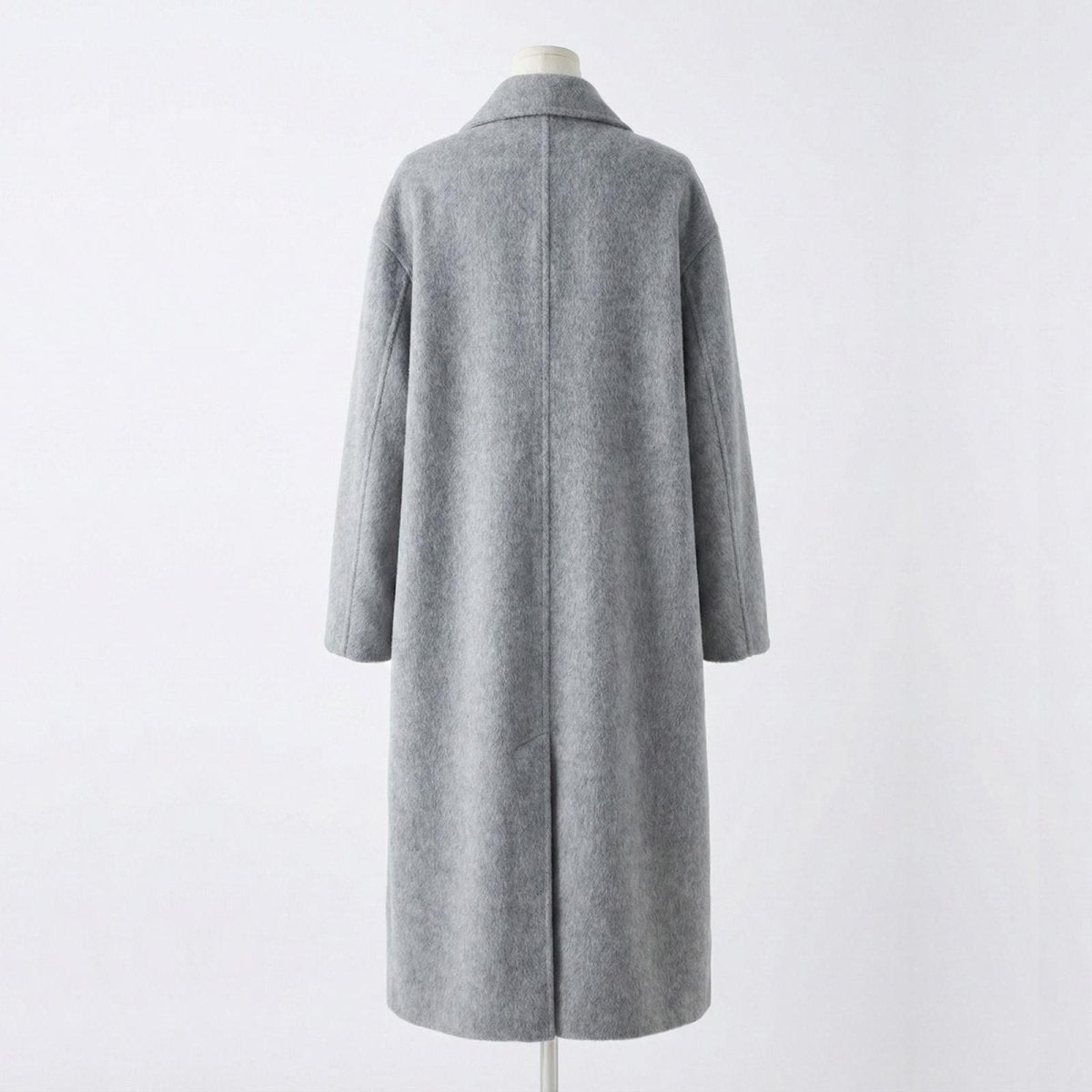 Flat lay product shot of the back of the Kouvr Fashion Maddie grey winter overcoat, showing the center seam and back vent detail.